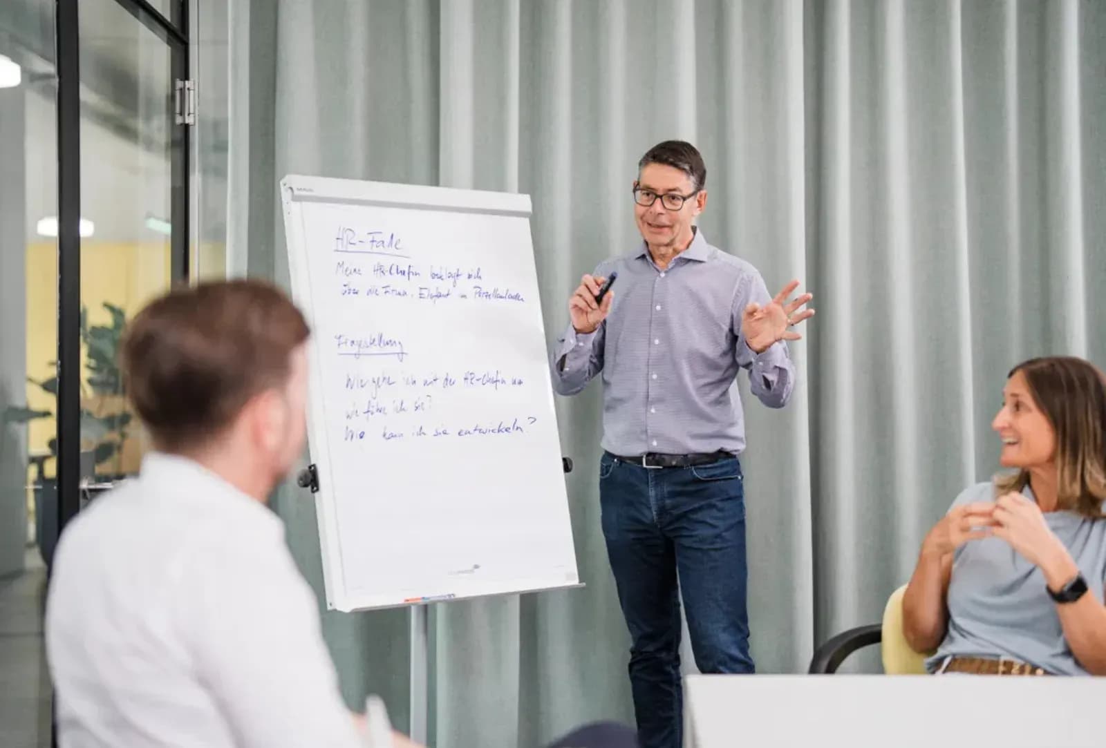 Hubert Lechner explaining a leadership case on a flip chart to a group of participants